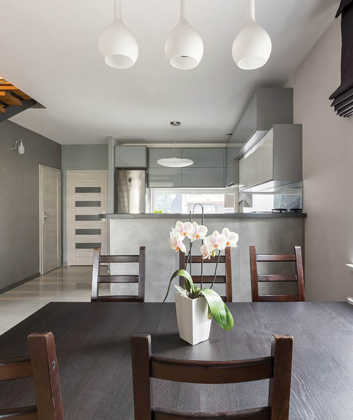 New, light villa interior with stylish dining set, window, staircase and open kitchen