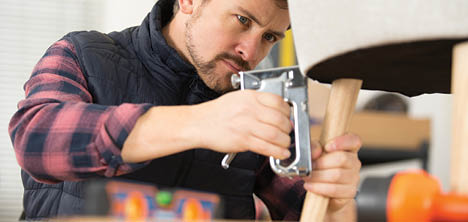 upholsterer using a staple gun