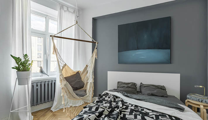 Nordic bedroom with double bed, hammock and modern painting