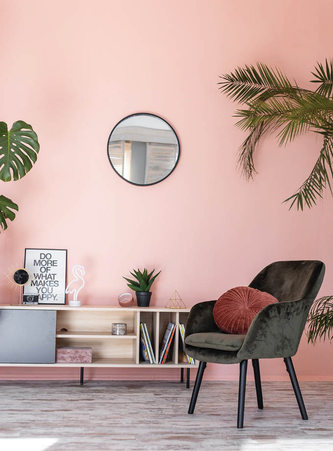 Minimalistic and luxury pastel pink home interior with green velvet design armchair, plants and mirror