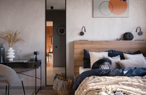 Eclectic decorated bedroom with desk, big mirror and comfortable bed with stylish bedclothes