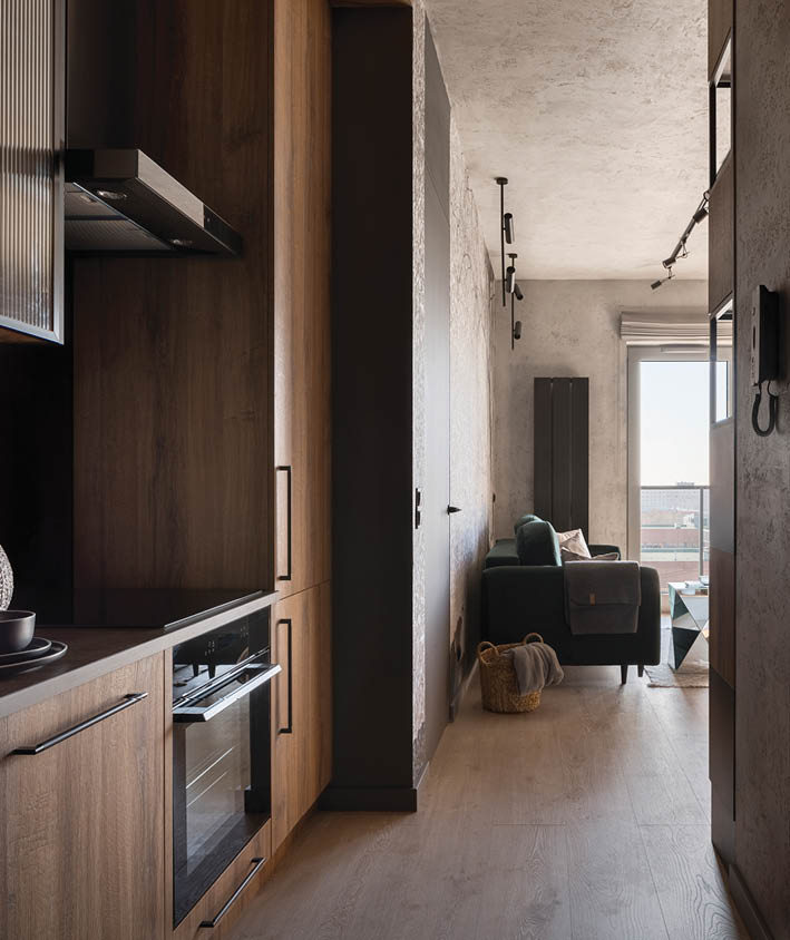 Modern kitchen with wooden furniture, floor and ceiling in apartment corridor