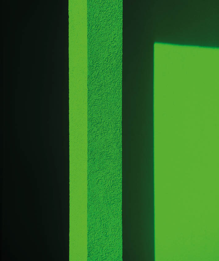 bright green abstract design of exterior neon green wall and dark black shadows creating geometric shapes and angles vertical backdrop background or wallpaper framed room for type content or logo text