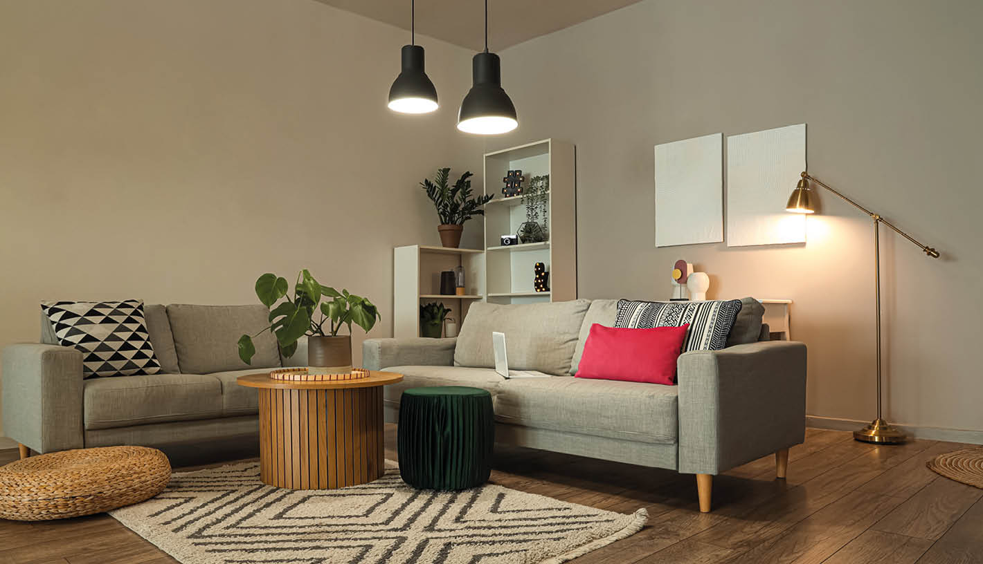 Interior of stylish living room with grey sofas and glowing lamps at evening