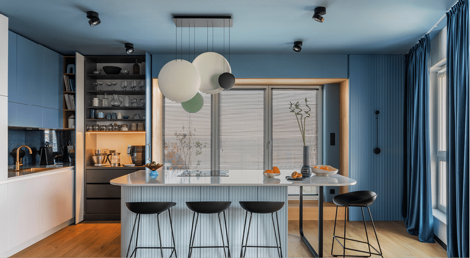 Interior design of kitchen space with marble island, black chockers, modern lamp, wooden wall, blue kitchen furnitures, vase with dried flowers and personal accessories. Home decor. Template. 