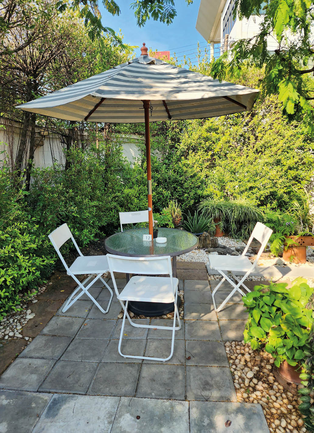 A relaxing corner in the garden. Furniture and big umbrella in the garden.