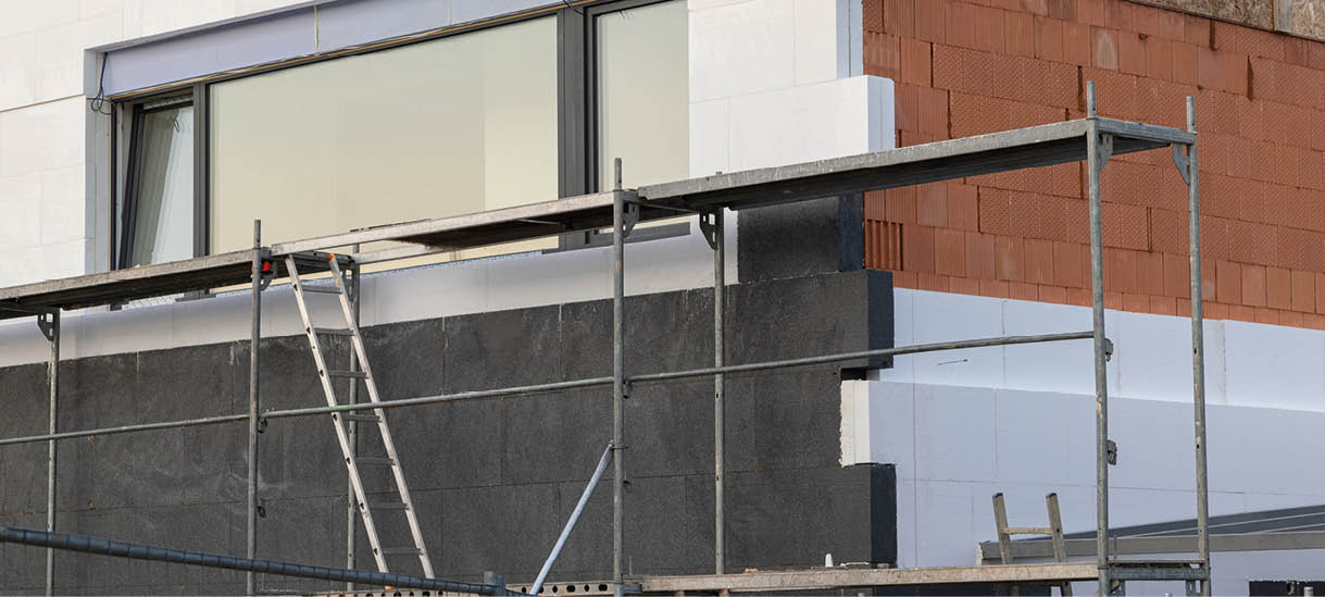 insulating the walls with modern thermal insulation materials. The new house construction process involves Exterior covering is applied at the construction site.