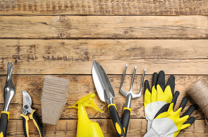 Flat lay composition with gardening tools on wooden background, space for text