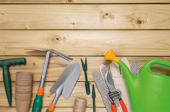 Set of garden tools and peat pots on wooden table with copy space for text.