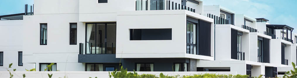 Brand new White apartment buildings in Phuket Thailand. Modern residential architecture with green trees and fence. Duplex apartment. Garden apartment. studio.