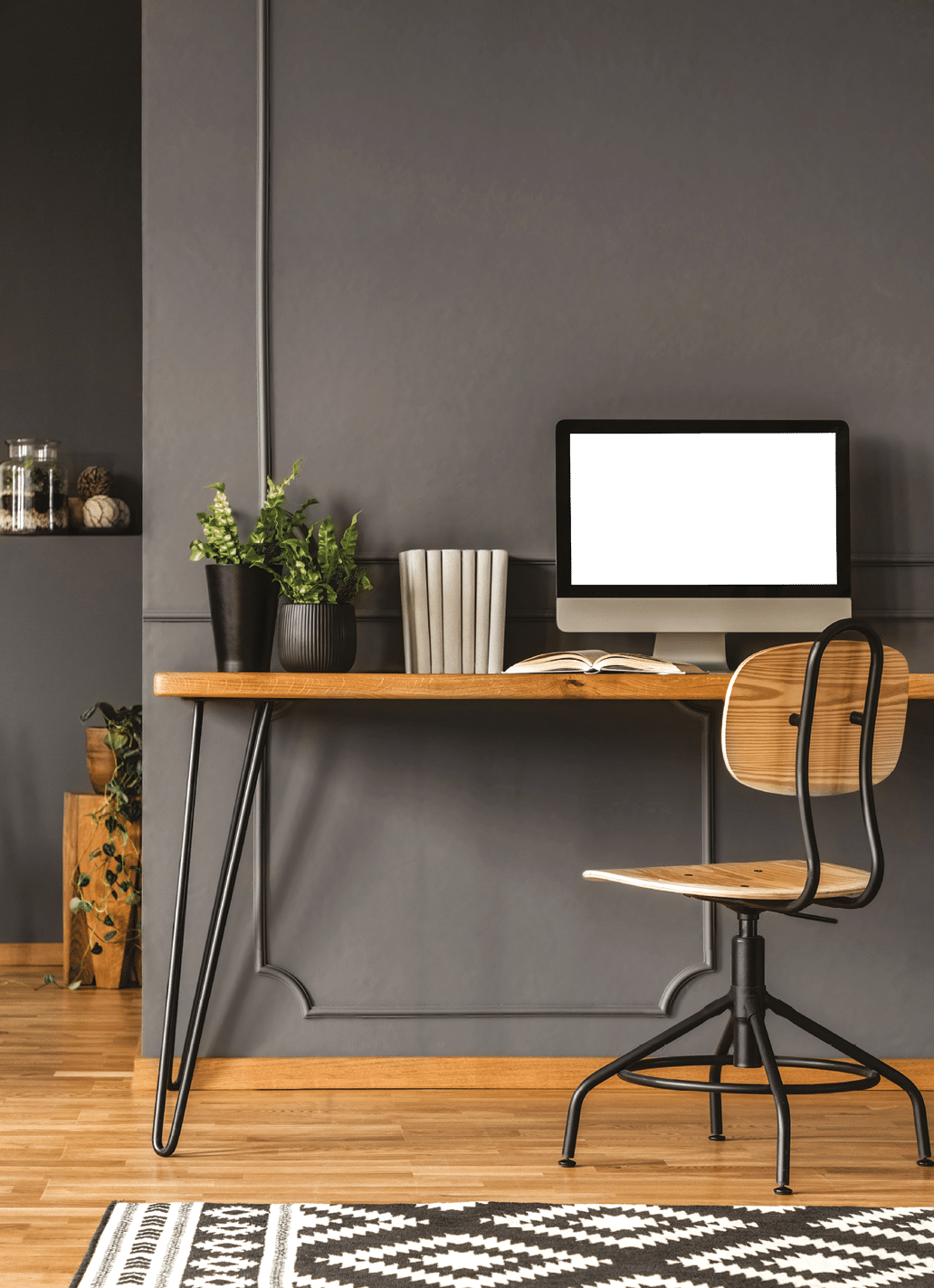 Patterned carpet in grey scandi workspace interior with computer monitor on wooden desk