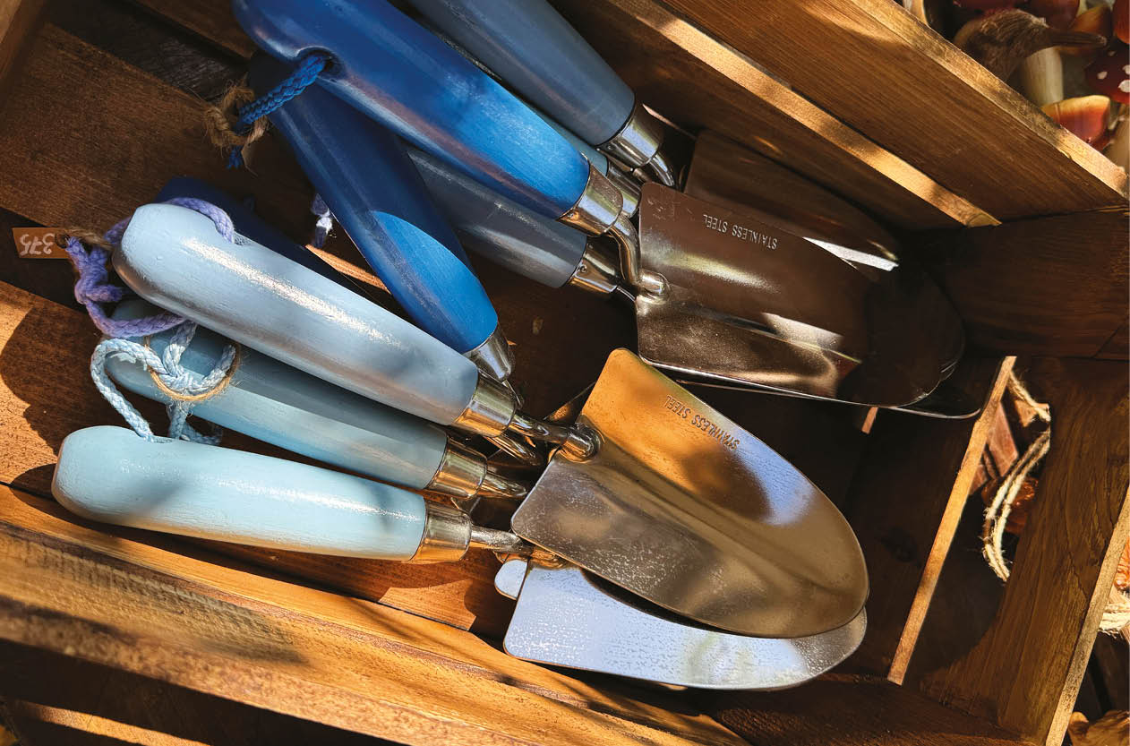 Small garden trowel with a blue handle, designed for planting flowers and working with soil.